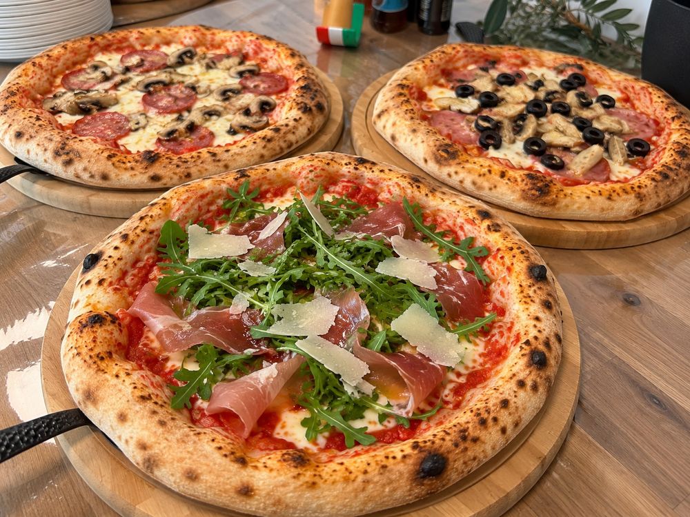 Tři neapolské pizzy Pizza DoVe na dřevěných podnosech